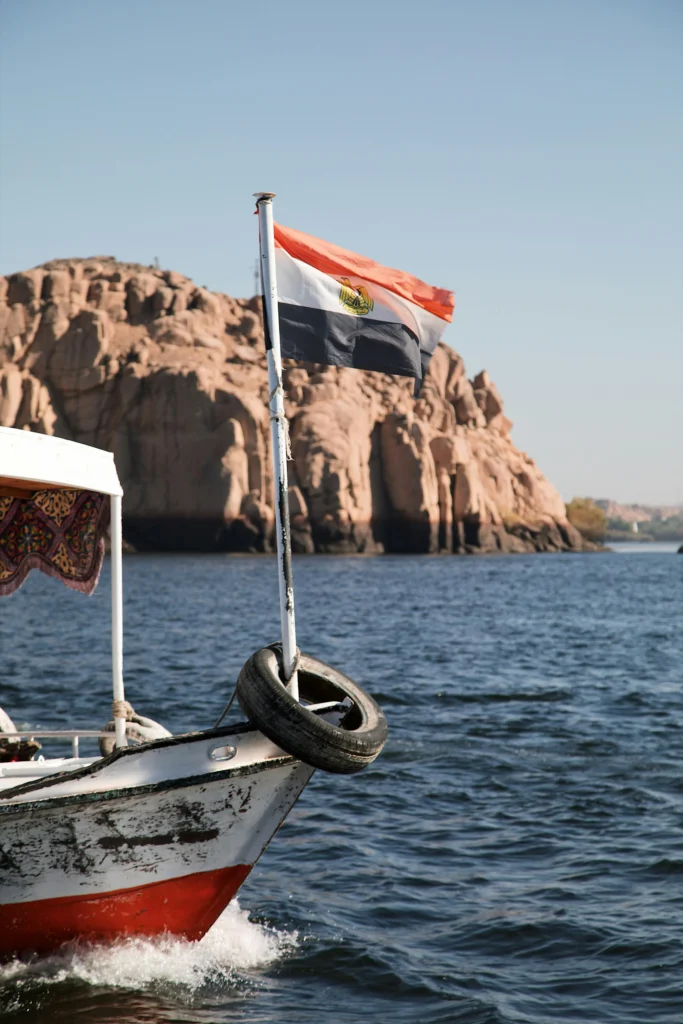 Tourists enjoying a scenic Nile River cruise with historic temples and lush landscapes in the background