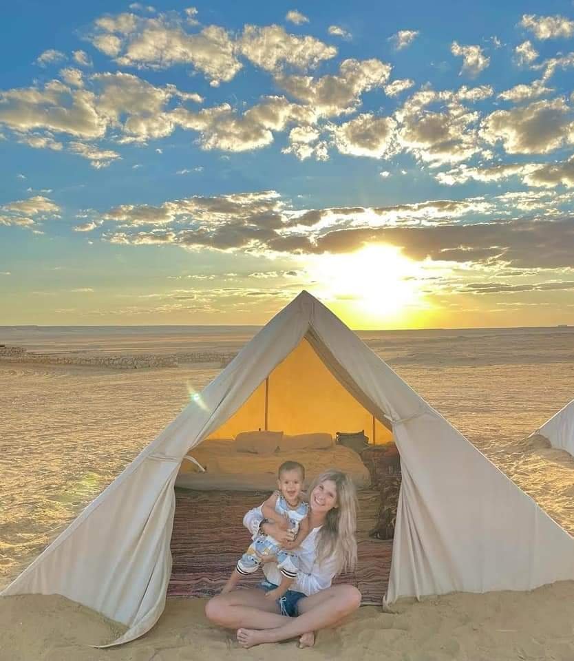 Couple enjoying a glamping tent in the Egyptian desert at sunrise